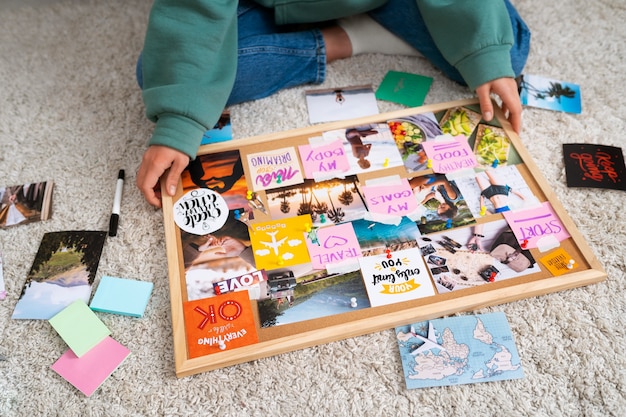 Kostenloses Foto frau, die einen hohen winkel des inspirierenden vision boards schafft