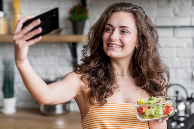 Kostenloses Foto frau, die einen kopfsalatsalat isst