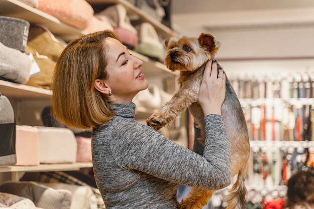 Frau, die einen niedlichen kleinen Hund an der Tierhandlung hält