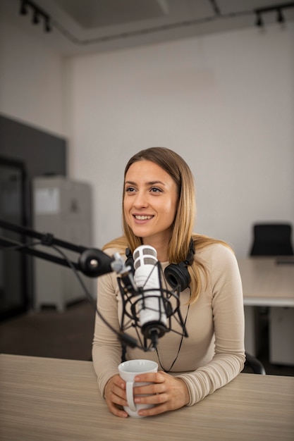 Frau, die einen Podcast im Radio mit einem Mikrofon tut