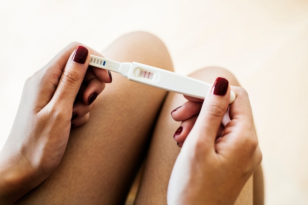 Kostenloses Foto frau, die einen positiven schwangerschaftstest hält