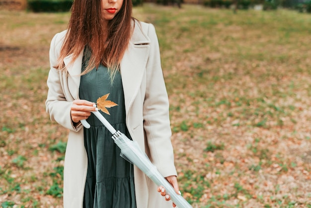 Kostenloses Foto frau, die einen regenschirm im herbst hält