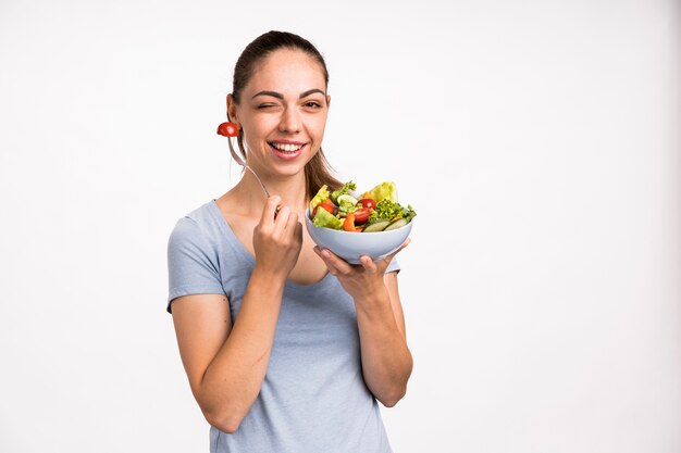 Frau, die einen Salat lächelt und hält