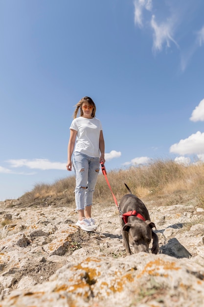 Frau, die einen Spaziergang mit ihrem Hund am Strand macht