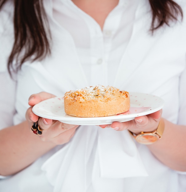 Kostenloses Foto frau, die einen teller mit apfelkuchen hält