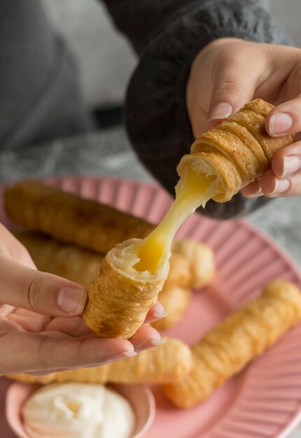 Frau, die einige traditionelle Tequenos genießt