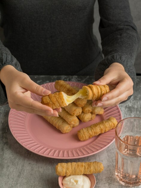 Frau, die einige traditionelle Tequenos genießt