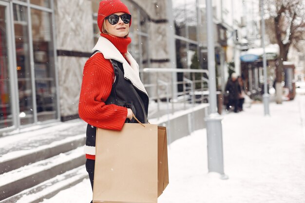Frau, die Einkaufstaschen an einem Außeneinkaufszentrum trägt