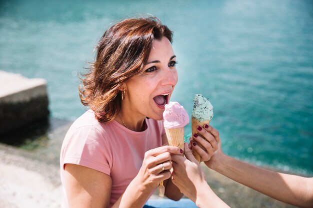 Frau, die Eiscreme von der Getreidefrau empfängt