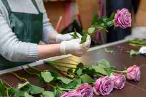 Kostenloses Foto frau, die elegante lila blumen arrangiert