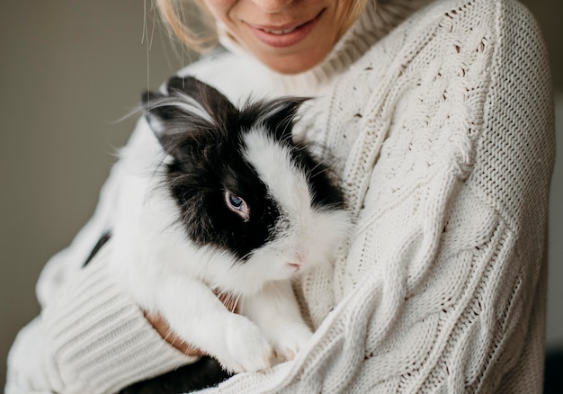 Kostenloses Foto frau, die entzückendes kaninchen streichelt