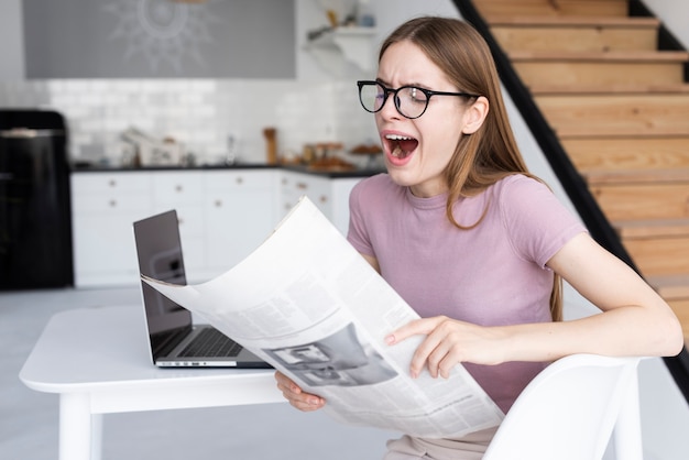 Frau, die etwas lustig in der Zeitung findet