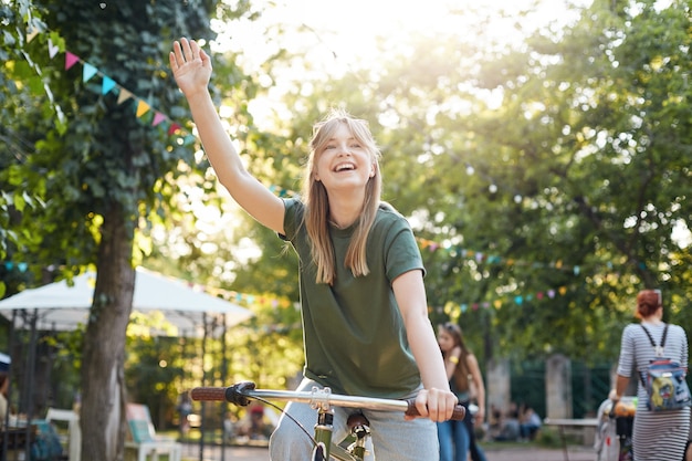 Frau, die fahrrad im park reitet. porträt einer jungen frau, die ein fahrrad im freien im stadtpark a reitet