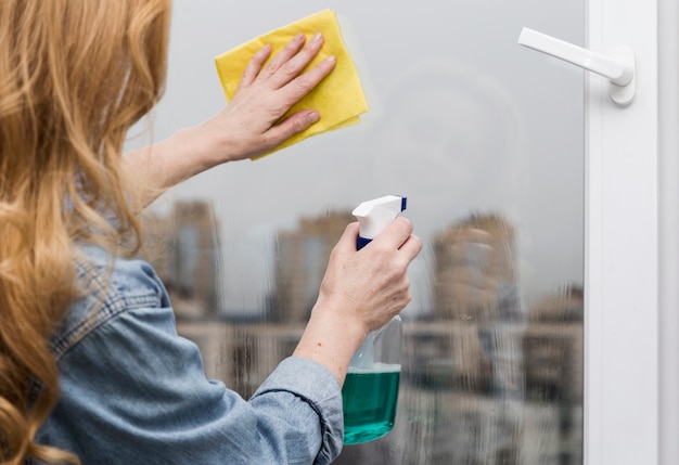 Frau, die Fenster wäscht