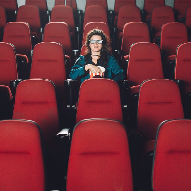 Frau, die Film im leeren Auditorium genießt