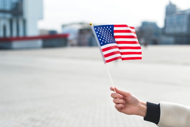 Frau, die Flagge von Amerika beim Feiern des Nationalfeiertags hält