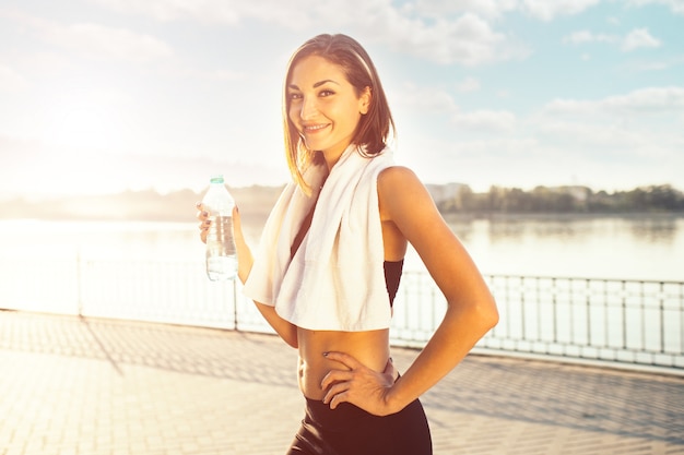 Frau, die flasche wasser und ein tuch hält