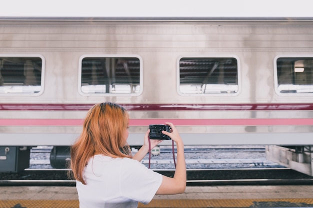 Frau, die Foto des Zugs beim Reisen macht