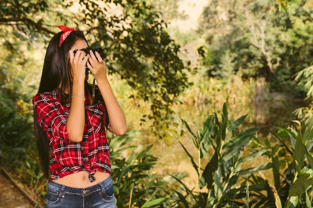 Frau, die Foto mit Kamera im Wald macht
