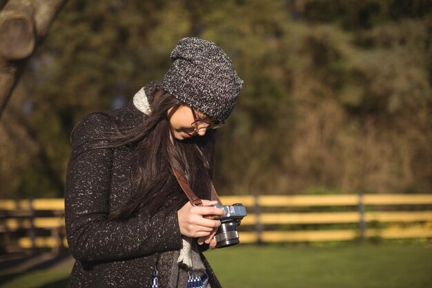 Frau, die Fotos auf Digitalkamera betrachtet