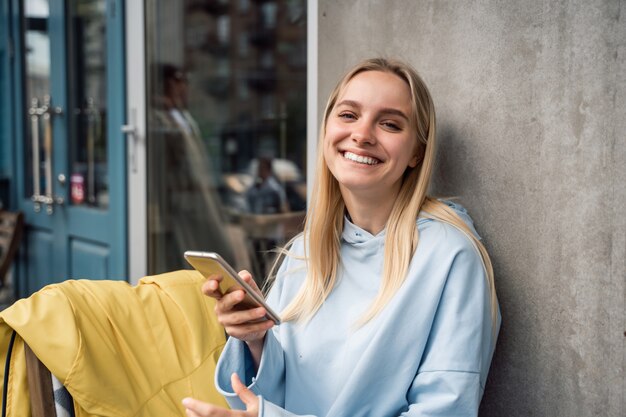 Frau, die geht und ein Smartphone in der Straße benutzt