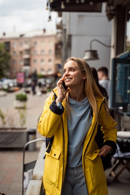 Frau, die geht und ein smartphone in der straße benutzt