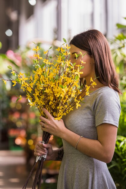 Frau, die gelbe Blumen riecht