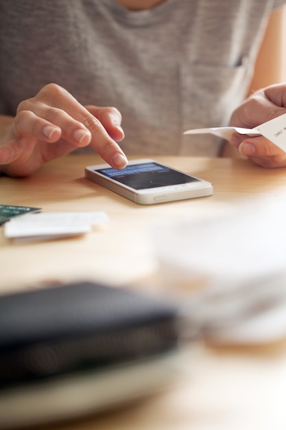 Frau, die Geld an ihrem Telefon zählt