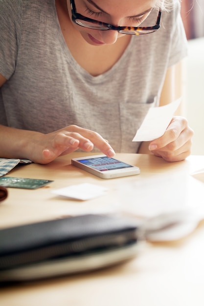 Kostenloses Foto frau, die geld an ihrem telefon zählt