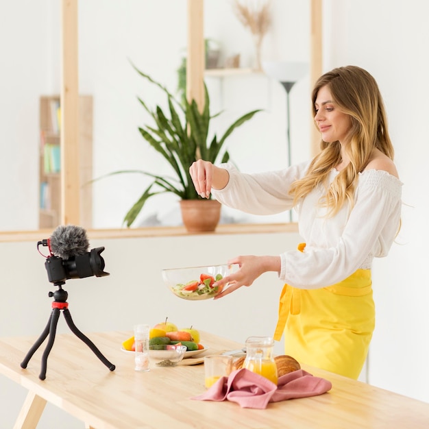 Kostenloses Foto frau, die gemüsesalat macht