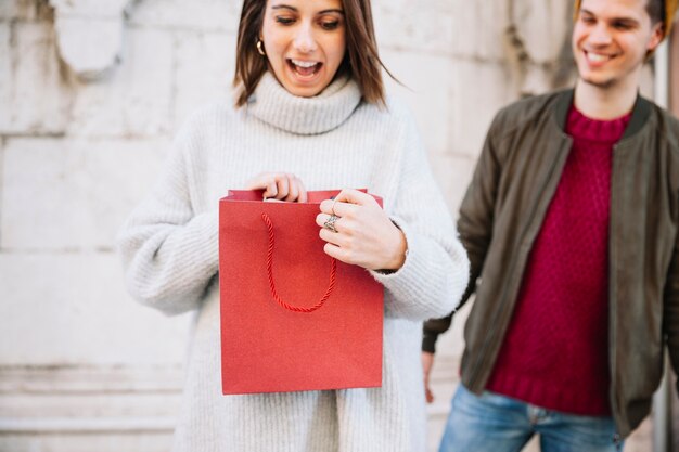 Frau, die Geschenk vom Mann betrachtet