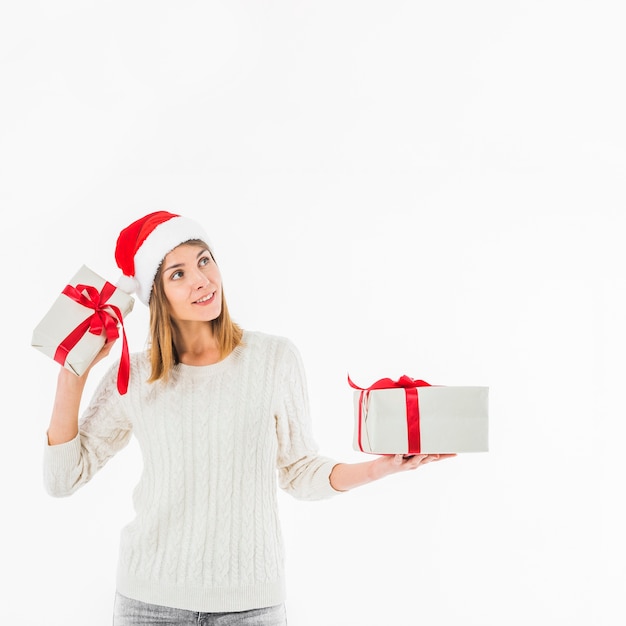 Frau, die Geschenkbox nahe Ohr hält