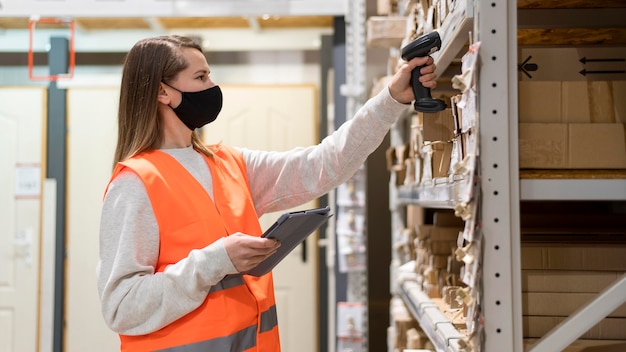 Kostenloses Foto frau, die gesichtsmaske am arbeitsplatz trägt