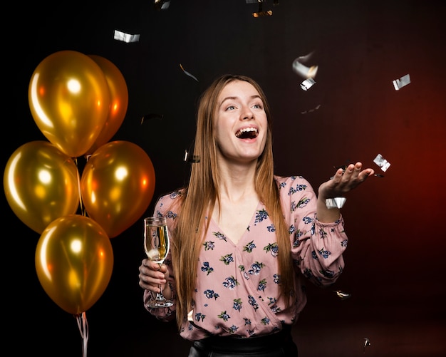 Kostenloses Foto frau, die glücklich ist und ein glas mit goldenen ballonen hält