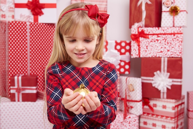 Frau, die goldenen Weihnachtsball hält