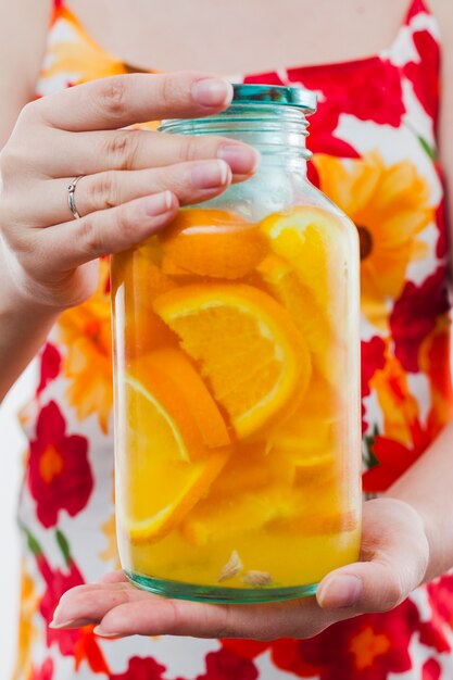 Frau, die große Flasche des Orangensaftgetränks hält