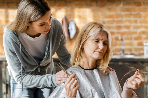 Frau, die Haarbüschel und Schere hält