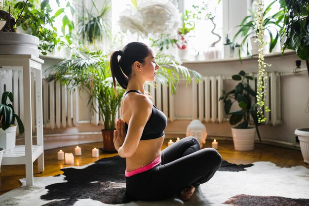 Frau, die Hände hinter Rückseite während der Meditation umklammert