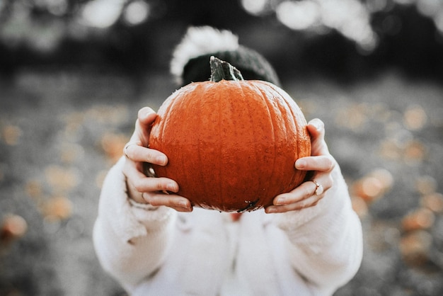 Frau, die Halloween-Kürbis in einer Farm hält