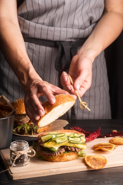 Frau, die Hamburger und Pommes-Nahaufnahme vorbereitet