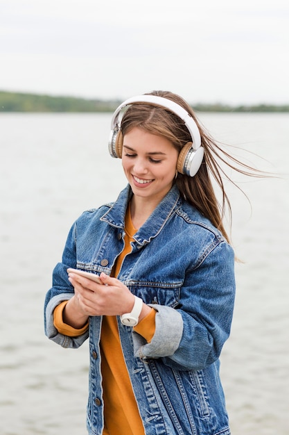 Frau, die Handy für Musik prüft