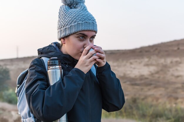 Frau, die heißen Kaffee trinkt. Winterabenteuer. Fernweh. Wandern und Reisen