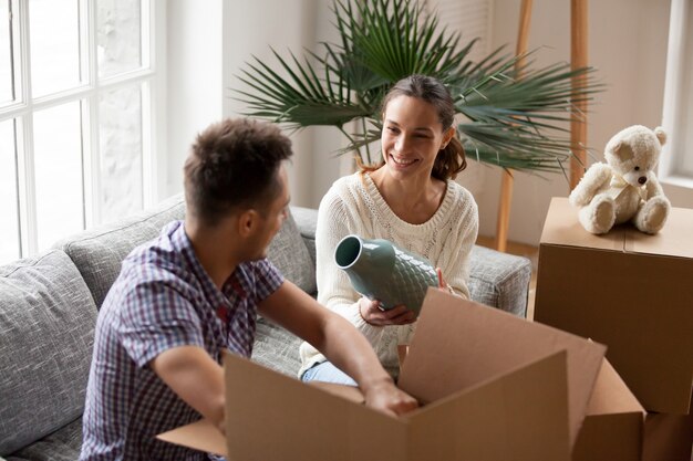 Frau, die helfenden Mannverpackungskästen des Vase am beweglichen Tag hält