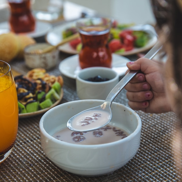 Frau, die herum sahnige Pilzsuppe, Orangensaft isst