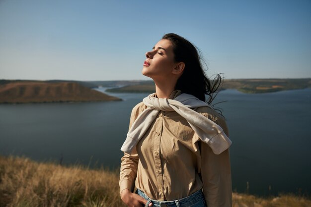 Frau, die hoch mit erstaunlicher Ansicht des Flusses dnjestr steht