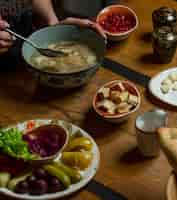 Kostenloses Foto frau, die hühnersuppe mit kräutern und gewürzen herum isst