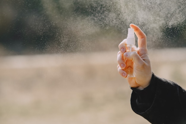 Frau, die Hygienespray hält