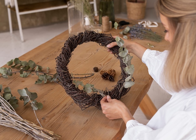 Kostenloses Foto frau, die ihr eigenes trockenblumenarrangement baut