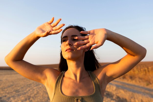 Frau, die ihr Gesicht von der Sonne im Freien beschattet