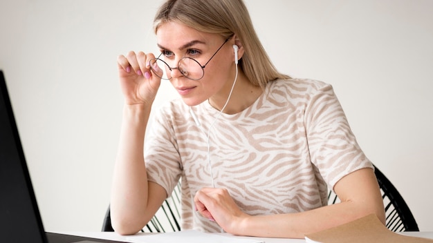 Frau, die ihre Lesebrille einstellt